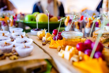 Burgerler, soğuk atıştırmalıklar, et ve salatalarla dolu açık büfe masası.