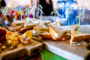 Burgerler, soğuk atıştırmalıklar, et ve salatalarla dolu açık büfe masası.