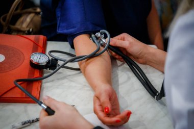 Kadın tıp doktor hastasını için kan basıncı ölçme görünümünü kapatın. Ellerini kapatın. Sağlık, sağlıklı yaşam ve tıbbi hizmet anlayışı