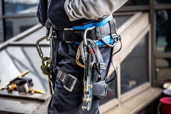 Close-up harnesses and gloves, Working at height equipment. Fall arrestor device for worker with double hooks for safety body harness on selective focus, Safety background and beautiful, Safety first