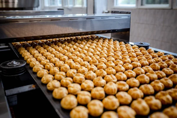 Profitrols on a conveyor belt at a bakery plant