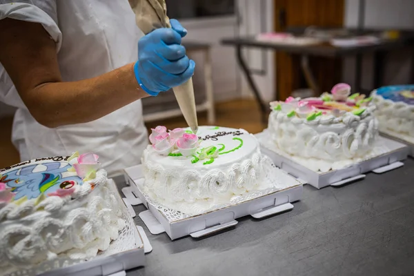 woman is preparing a cake at a bakery plant