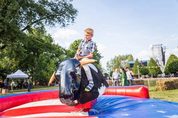 Minsk, Beyaz Rusya - 1 Mayıs 2017: Bir çocuk güvenli bir Mekanik boğaya eğlence sürüş sarılı iken adrenalin sahiptir