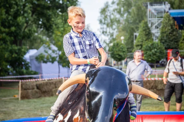 Minsk, Beyaz Rusya - 1 Mayıs 2017: Bir çocuk güvenli bir Mekanik boğaya eğlence sürüş sarılı iken adrenalin sahiptir