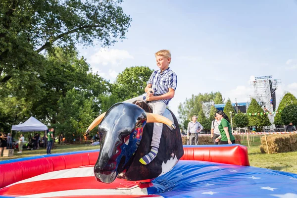 Minsk, Beyaz Rusya - 1 Mayıs 2017: Bir çocuk güvenli bir Mekanik boğaya eğlence sürüş sarılı iken adrenalin sahiptir