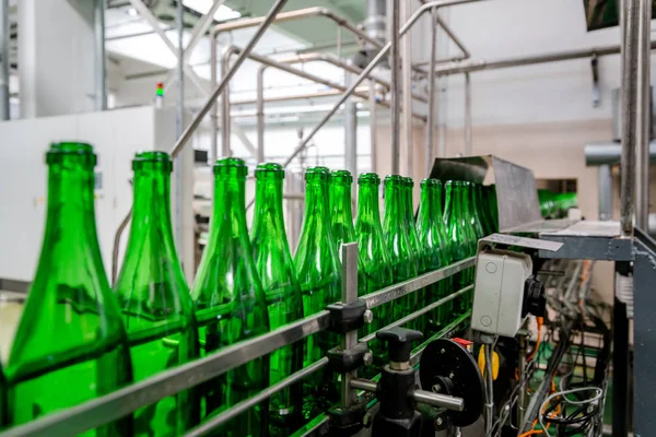 bottles with champagne wine are moving along the conveyor at the factory of grape and sparkling wine