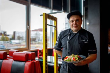 Minsk, Beyaz Rusya - 1 Mayıs 2017: şef aşçı restoranda lezzetli yemekler sunar