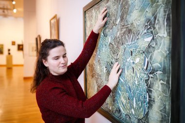 Minsk, Beyaz Rusya - 20 Yanuary, 2018: kör kadın dokunuşlar eller müzede dokunsal resim sergisi
