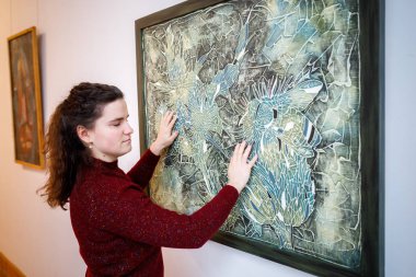 Minsk, Beyaz Rusya - 20 Yanuary, 2018: kör kadın dokunuşlar eller müzede dokunsal resim sergisi