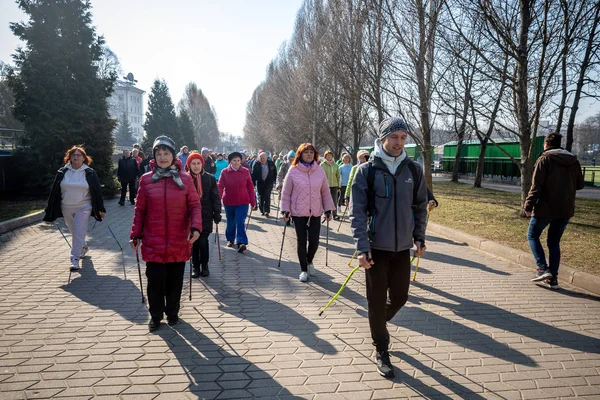 Минск, Белоруссия - 1 марта 2019 года: пожилые люди занимаются скандинавской ходьбой — стоковое фото