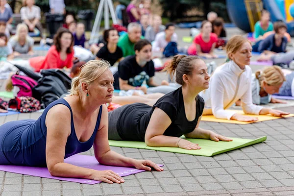 MINSK, BELARUS - 1 JUNIO, 2019: muchas personas hacen yoga en el parque — Foto de Stock