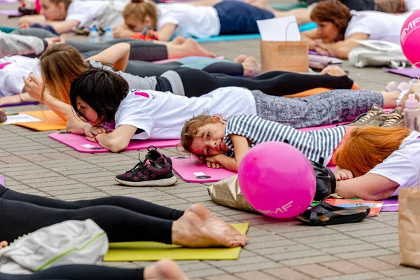 MINSK, BELARUS - 1 JUNIO, 2019: muchas personas hacen yoga en el parque — Foto de Stock