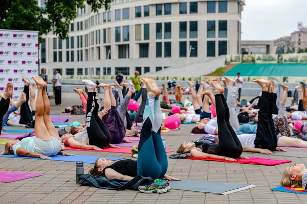 MINSK, BELARUS - 1 JUNIO, 2019: muchas personas hacen yoga en el parque — Foto de Stock