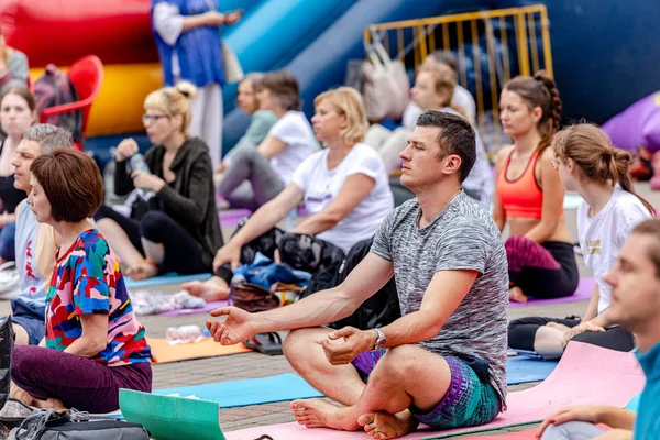 MINSK, BELARUS - 1 JUNIO, 2019: muchas personas hacen yoga en el parque — Foto de Stock