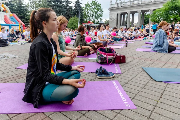 MINSK, BELARUS - 1 JUNIO, 2019: muchas personas hacen yoga en el parque — Foto de Stock