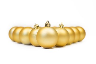 Beyaz arka planda yıldızlarla altın Noel topları.