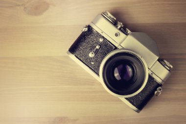 Ahşap bir masada klasik fotoğraf makinesi.
