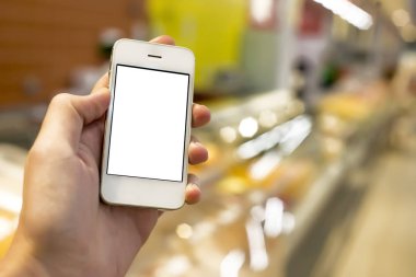Mobil akıllı telefon süpermarket üzerinde tutan adam el bulanıklık arka plan, iş kavramı
