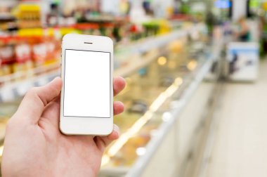 Mobil akıllı telefon süpermarket üzerinde tutan adam el bulanıklık arka plan, iş kavramı