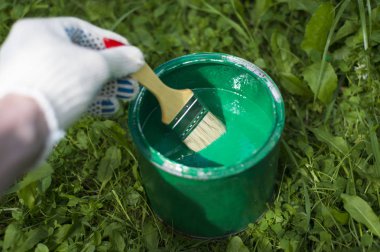 Yeşil boya ile bir olabilir bir fırça tutan el