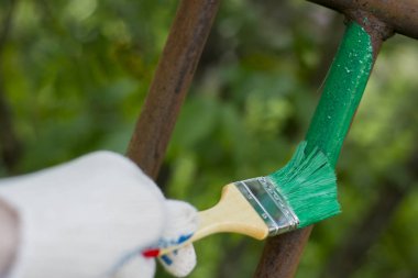 Beyaz eldiven giyen ve bir boya fırça ile boyama el.