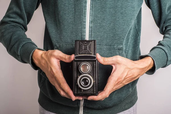 Vintage camera in hand on green