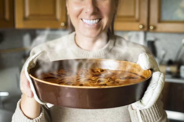 Fırın tepsisi hazır kekle tutan genç kadın