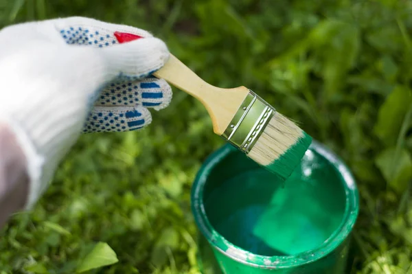 Yeşil boya ile bir olabilir bir fırça tutan el