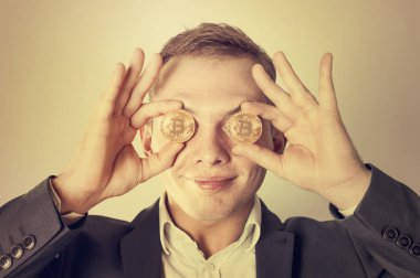 Bir adam bir sikke bitcoin gözlerinin önünde tutar. Para (bitcoin gözünde)