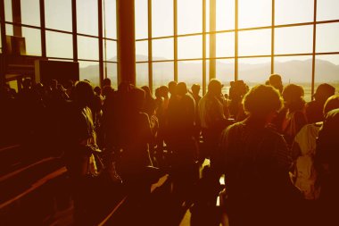 Uçak havaalanında dağ arka plan ile terminal için bekleyen siluet kalabalık insan