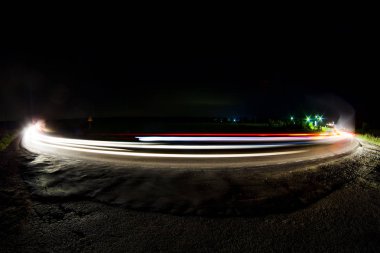 Uzun pozlama üzerinde araba farlar vardır.