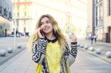 Bir kız sokakta yürürken ve telefonda konuşurken