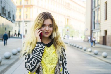 Bir kız sokakta yürürken ve telefonda konuşurken