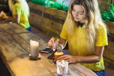 Fincan kahve ile güzel kız bir kafede oturuyor