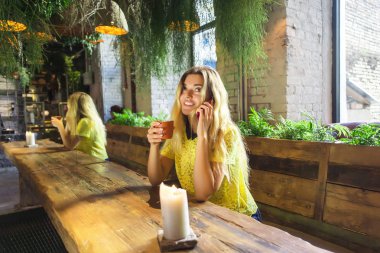 Fincan kahve ile güzel kız bir kafede oturuyor