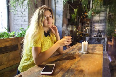 Fincan kahve ile güzel kız bir kafede oturuyor