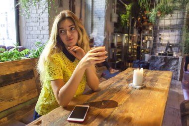 Fincan kahve ile güzel kız bir kafede oturuyor