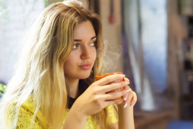 Fincan kahve ile güzel kız bir kafede oturuyor