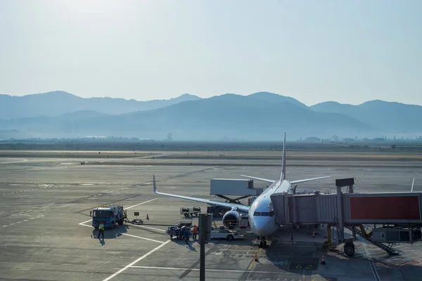 Loading cargo on the plane in airport, view through window