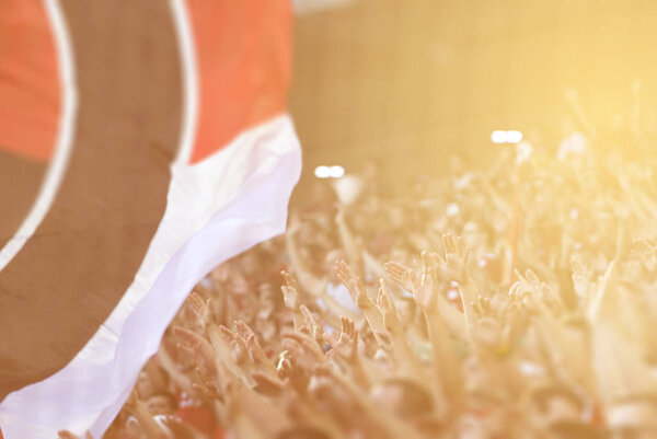 Футбольные болельщики аплодируют на трибуне стадиона
