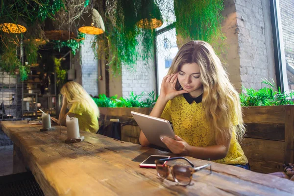 Tablet ile güzel kız bir kafede oturuyor