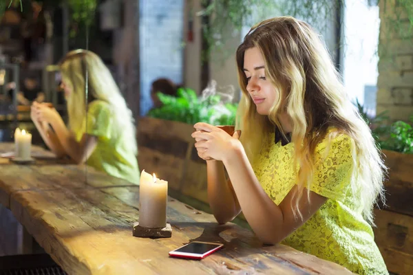 Fincan kahve ile güzel kız bir kafede oturuyor