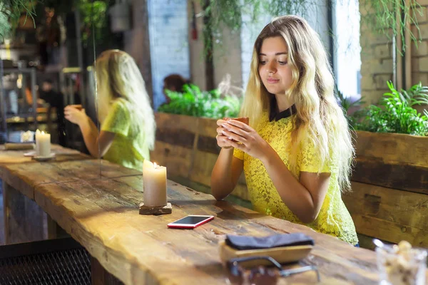 Fincan kahve ile güzel kız bir kafede oturuyor