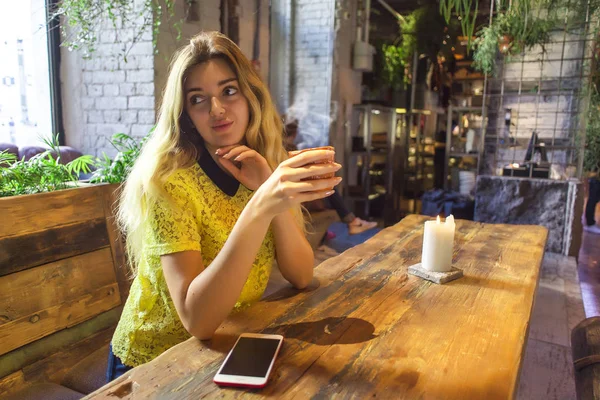 Fincan kahve ile güzel kız bir kafede oturuyor