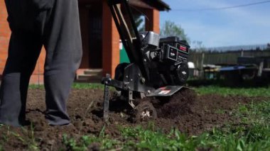 Rusya, Dmitrov, Haziran 2018: Çiftçi bir Kültüvatör ile toprak yetiştirerek. Tarım. mini traktör.