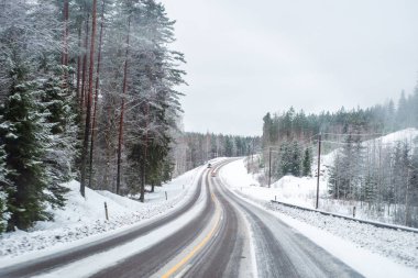 Işıklı bir kar kaplı yolda araba.