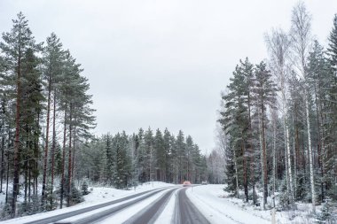 Işıklı bir kar kaplı yolda araba.