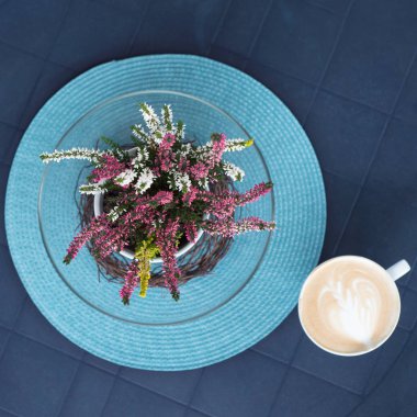 Görünümü görüntü çiçek sonraki mavi plastik masa üzerinde kahve için top..