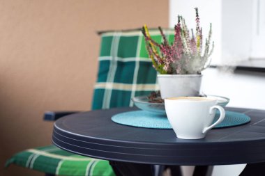 yanında kahve mavi plastik masa üzerinde çiçekler.