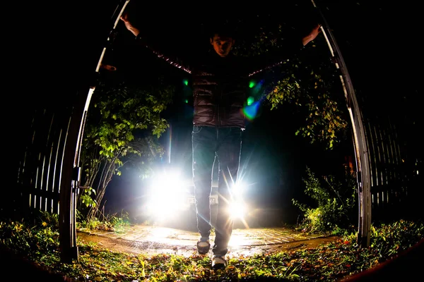 Genç bir adam araba dışarı götürmek için kapı açar